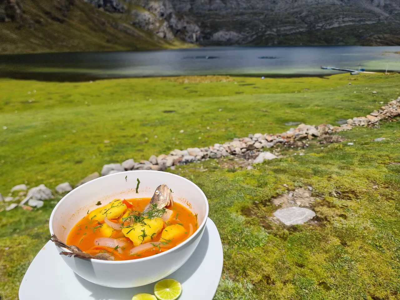Plato de sudado de trucha con la laguna Canrash de fondo