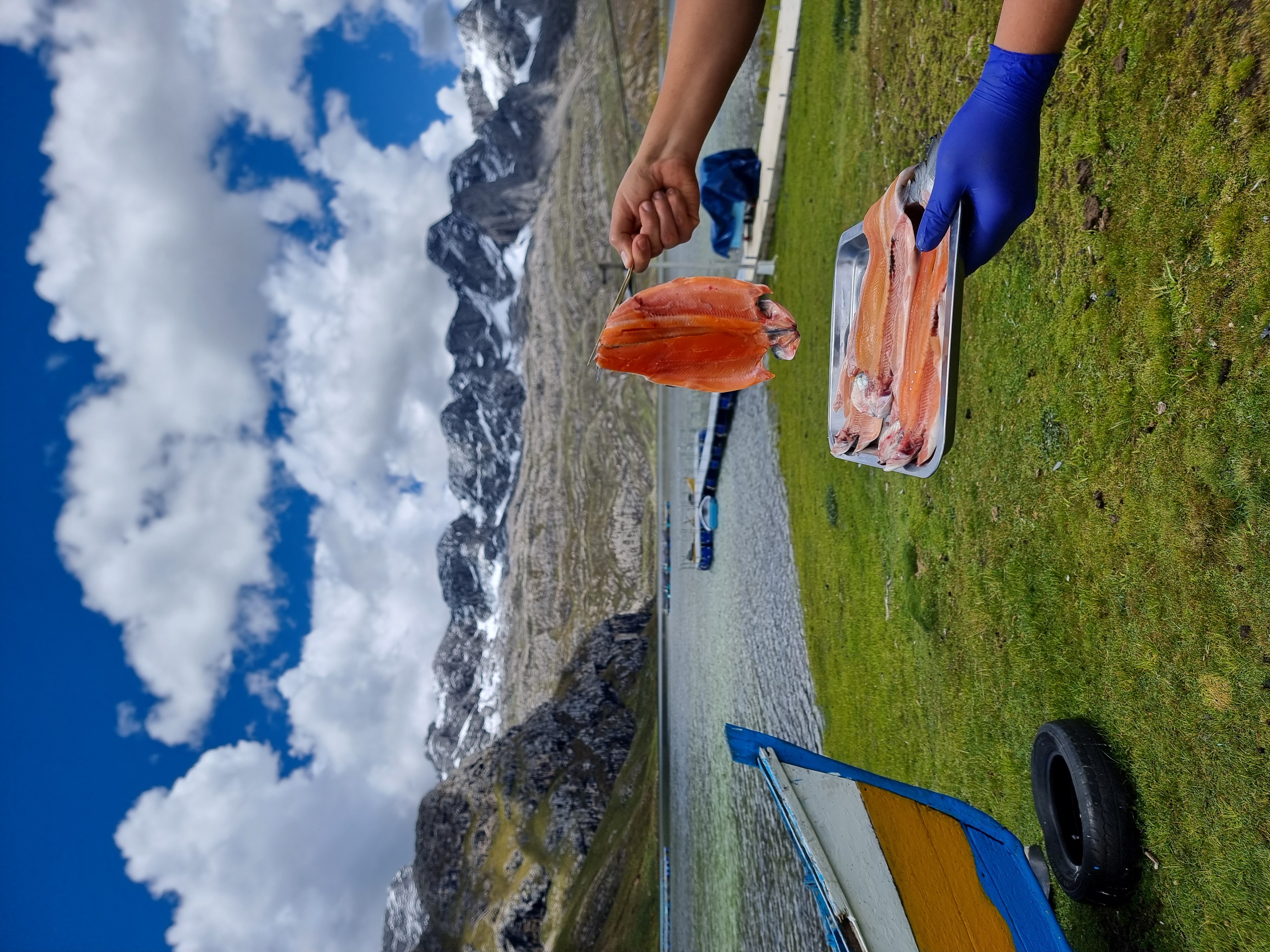 Chef presentando trucha fresca con vista a la laguna